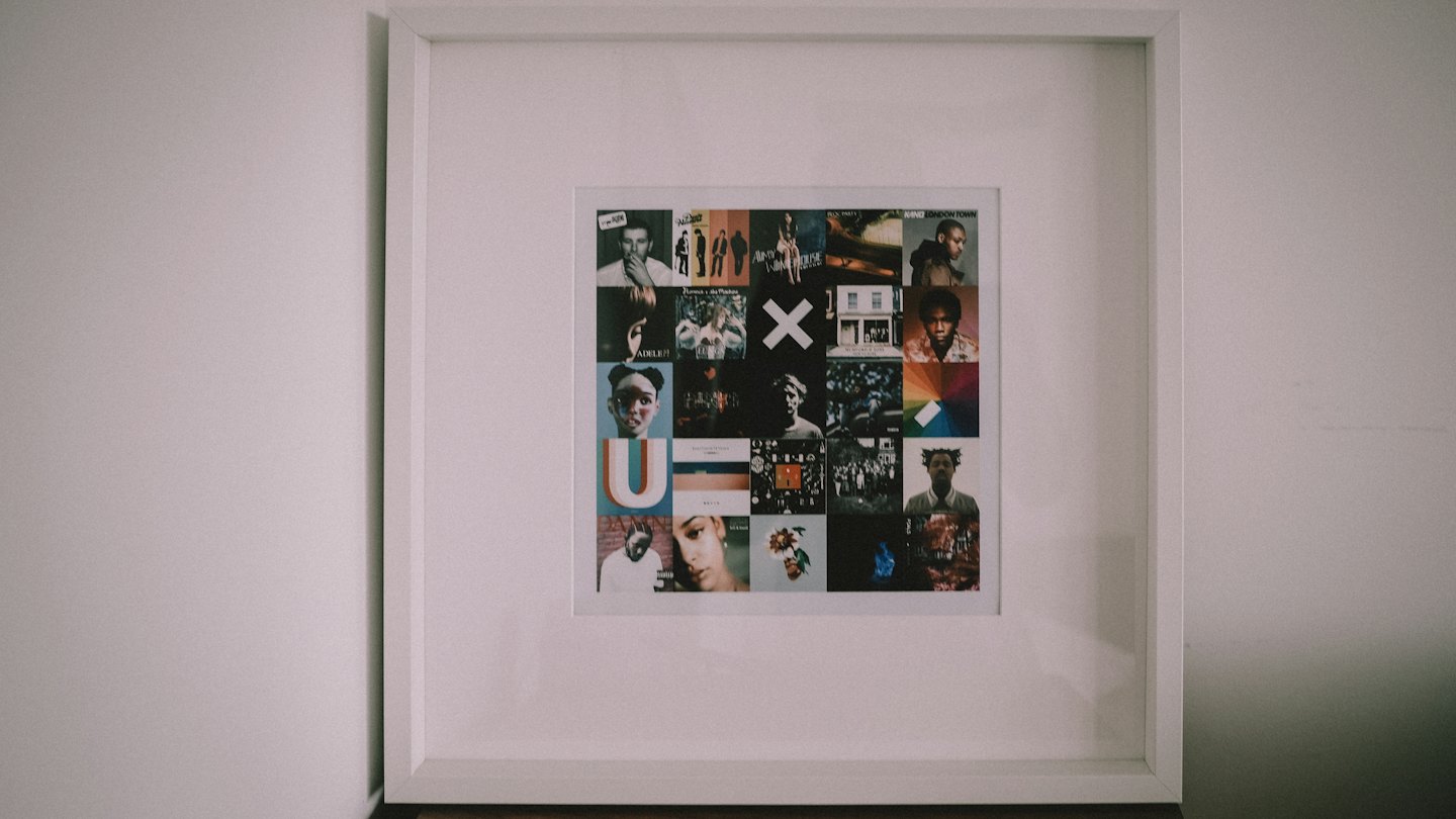 Collage of album covers in a white frame on a white wall.