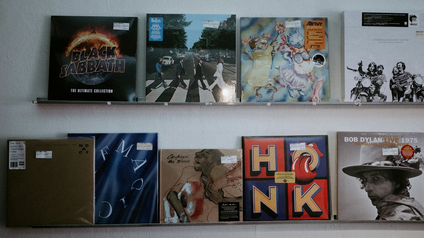 Vinyl record albums displayed neatly on metal wall shelves.